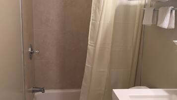 Un baño con bañera, inodoro y cortina de ducha.