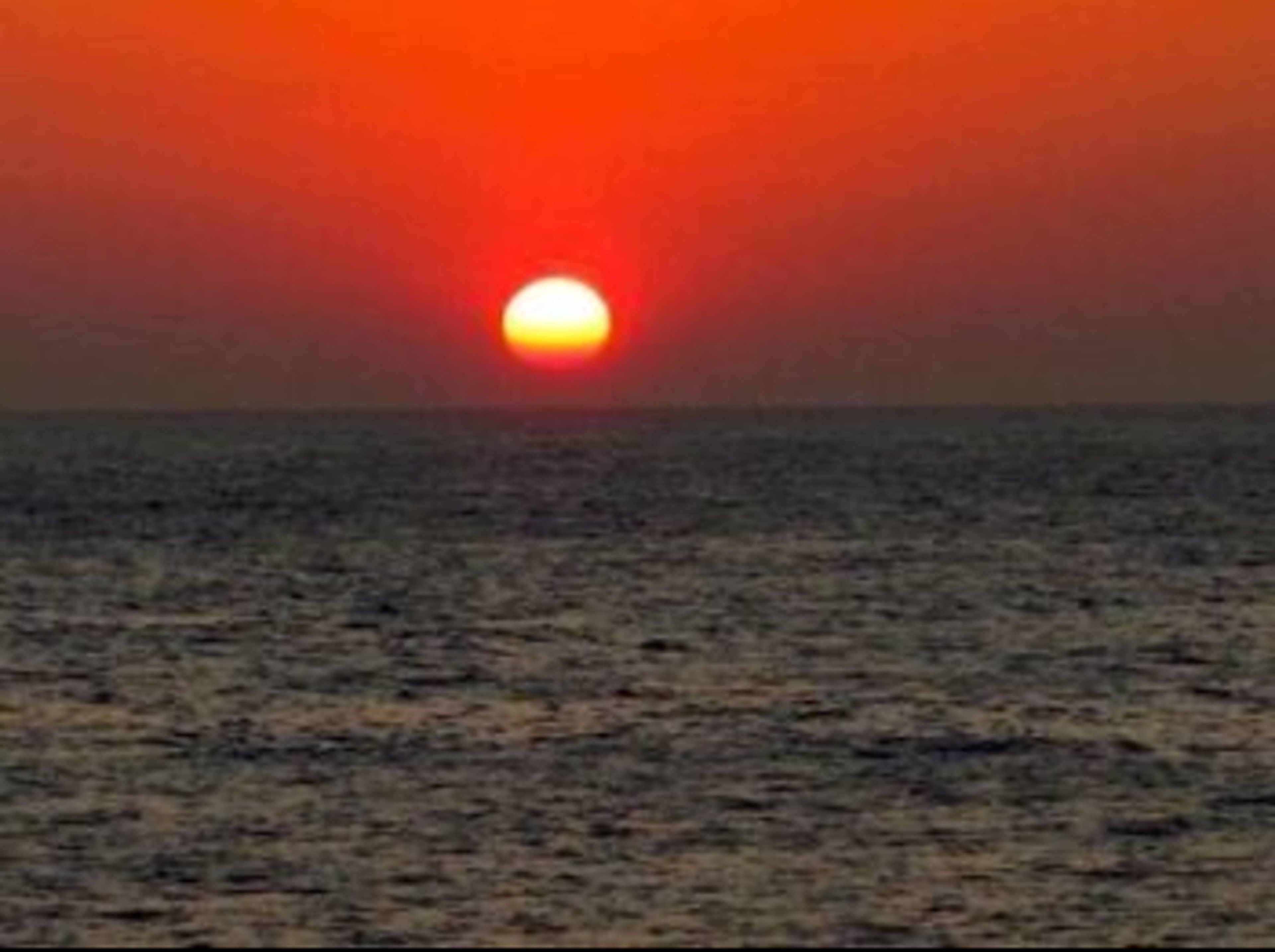 Tramonto sull'oceano con orizzonte sereno.