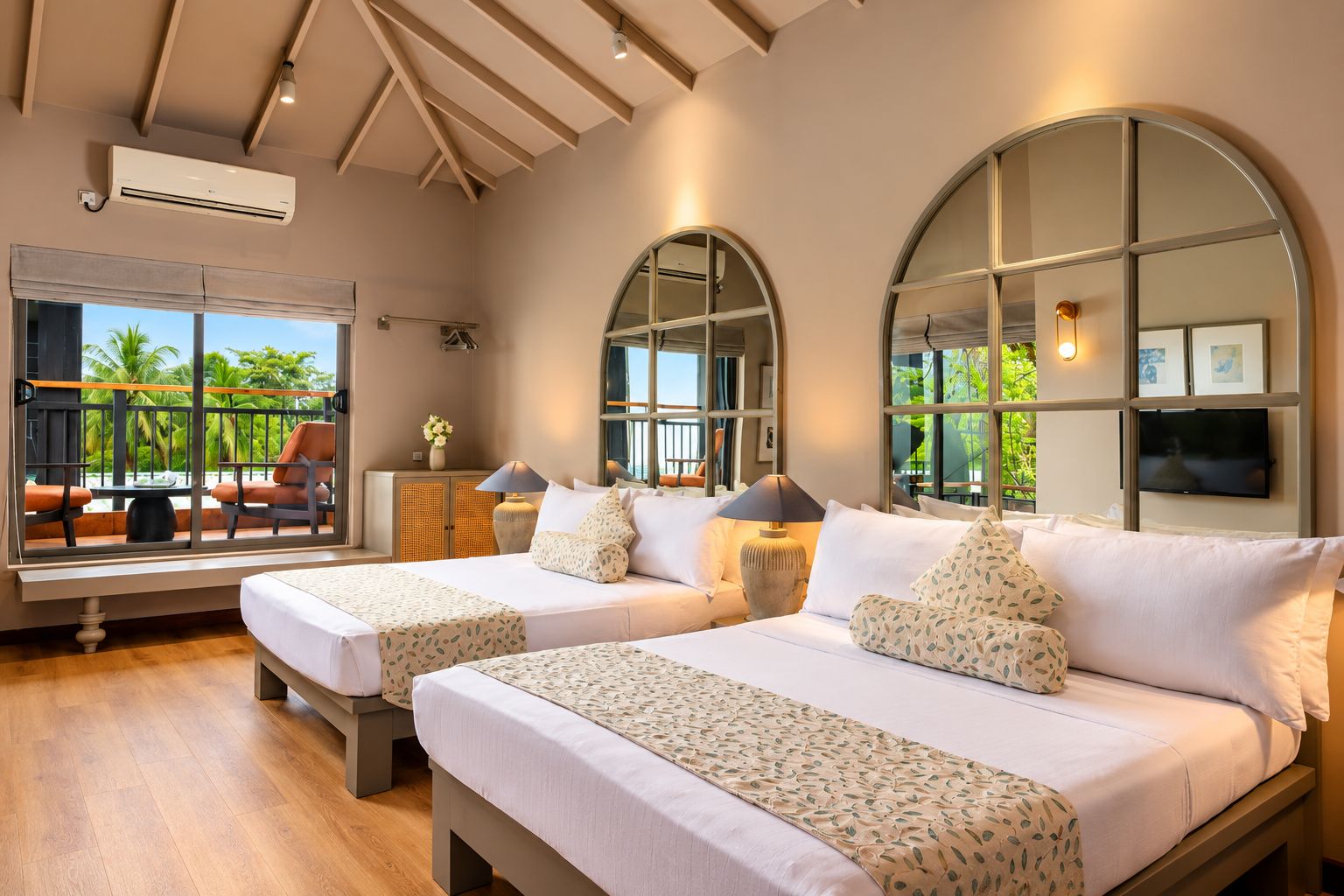 A hotel room with two beds, a large arched window, a TV, and a view of palm trees.