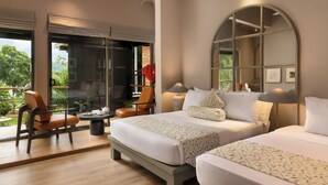 Une chambre d’hôtel moderne dotée d’un grand lit, d’un coin salon avec une table et offrant une vue sur l’extérieur.