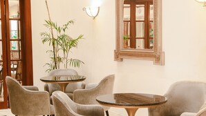 A room with a round table, six chairs, a large mirror, and a potted plant. - Los Tallanes Hotel & Suites (Lima)