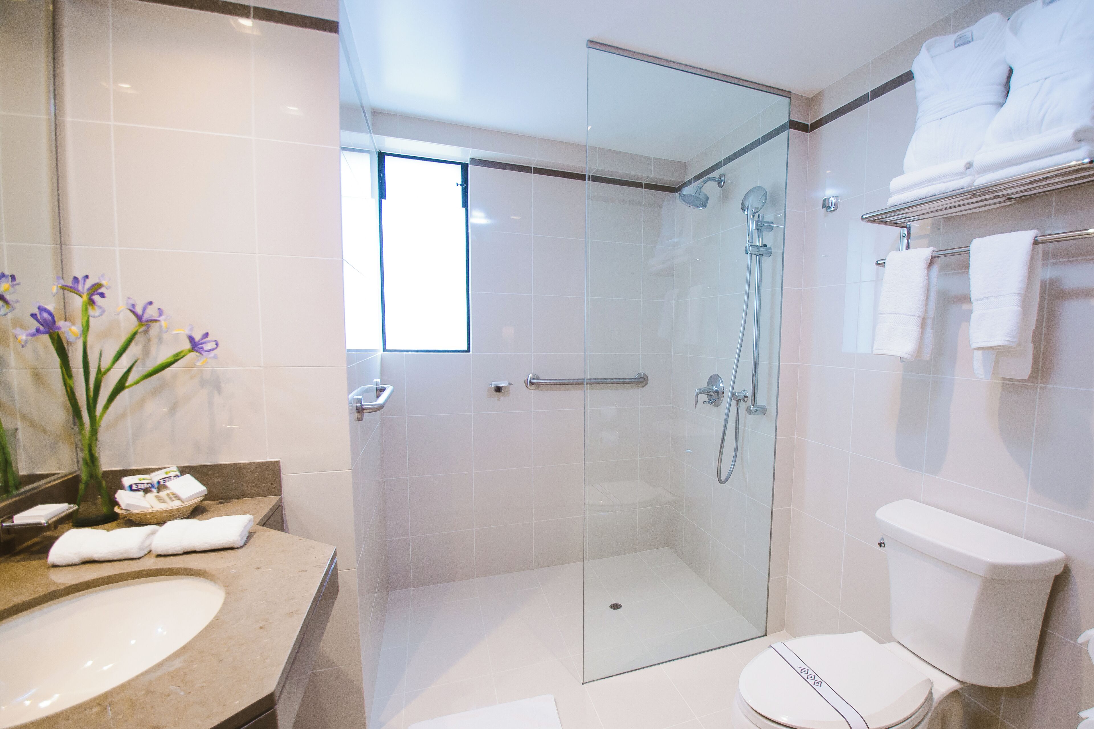 Un baño moderno con ducha de vidrio, inodoro y lavabo.