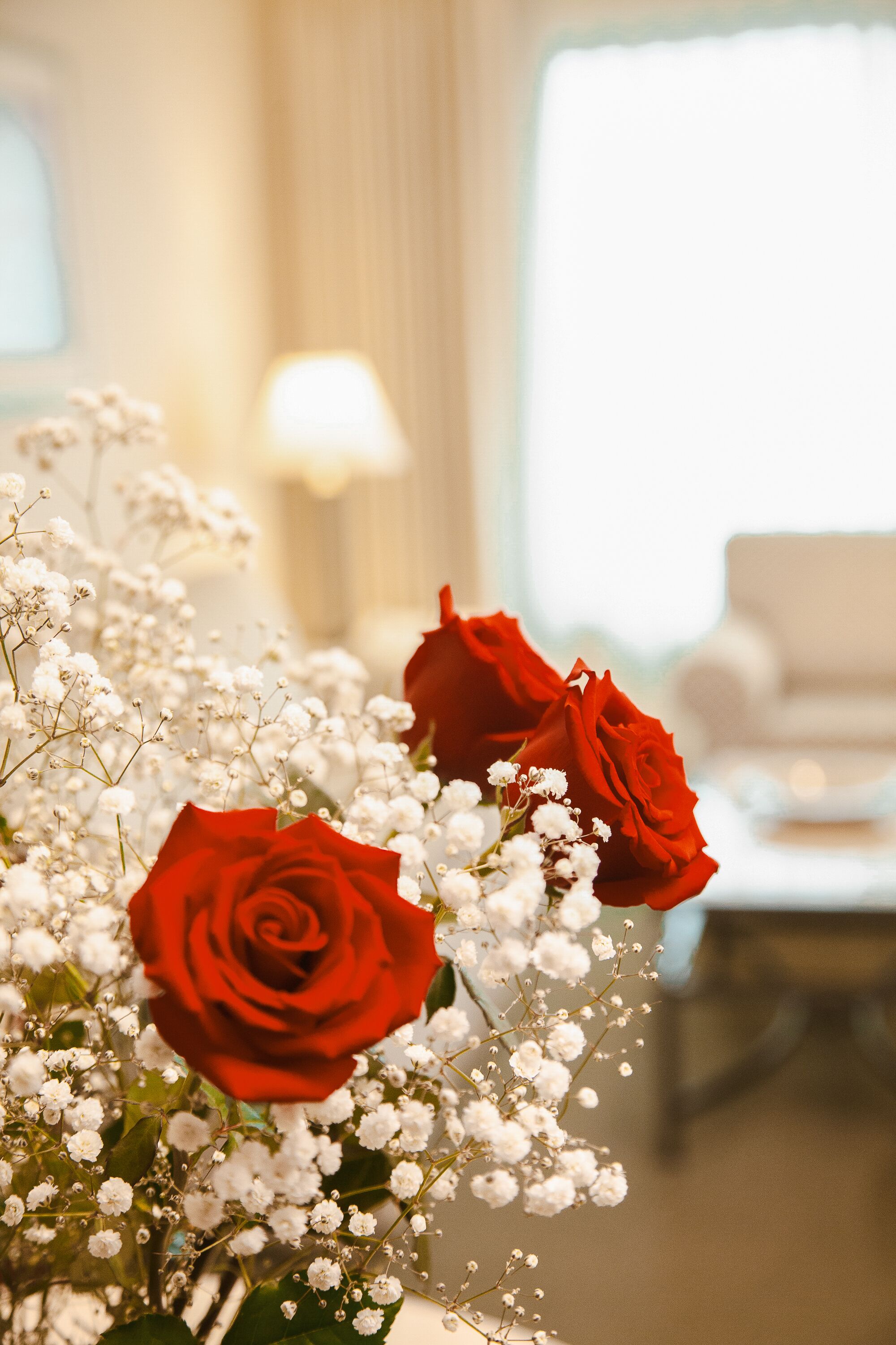 A bouquet of red roses and white baby's breath flowers.