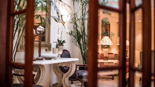 A dining area with a marble table, ornate chairs, and potted plants. - Los Tallanes Hotel & Suites (Lima)
