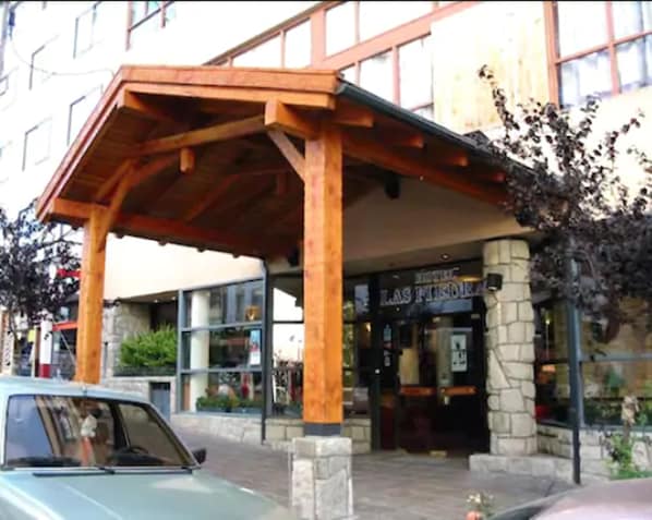 Un edificio con un porche de madera y pilares de piedra.