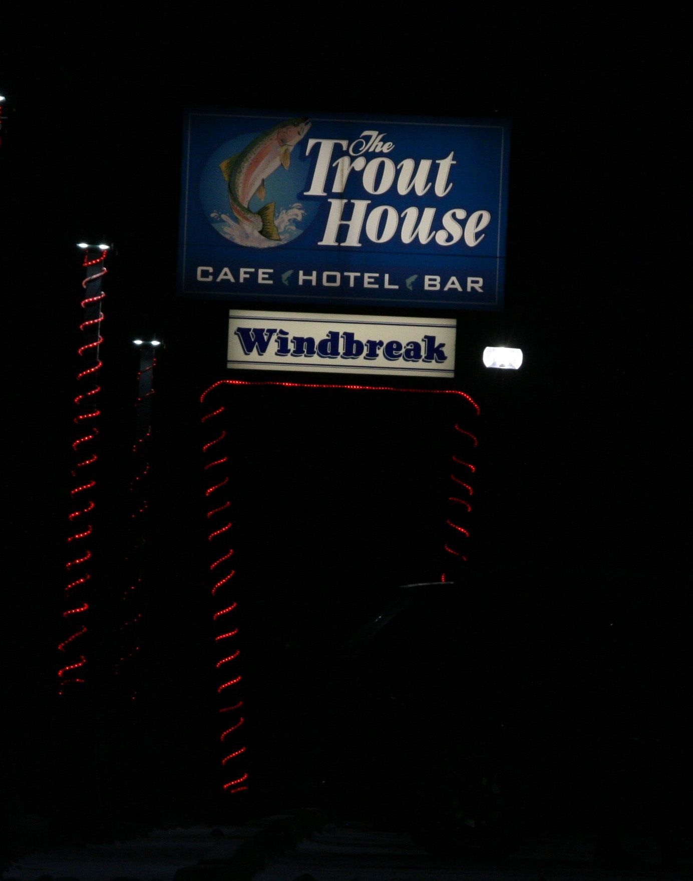 A sign for The Trout House, a cafe, hotel, and bar.