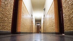 En lång, smal hall med väggar som har en tydlig struktur och ett polerat golv.