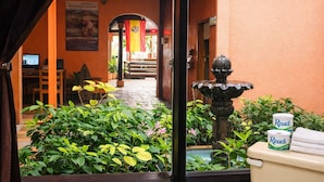 Un patio con una fuente, plantas en macetas y un inodoro Resudi.