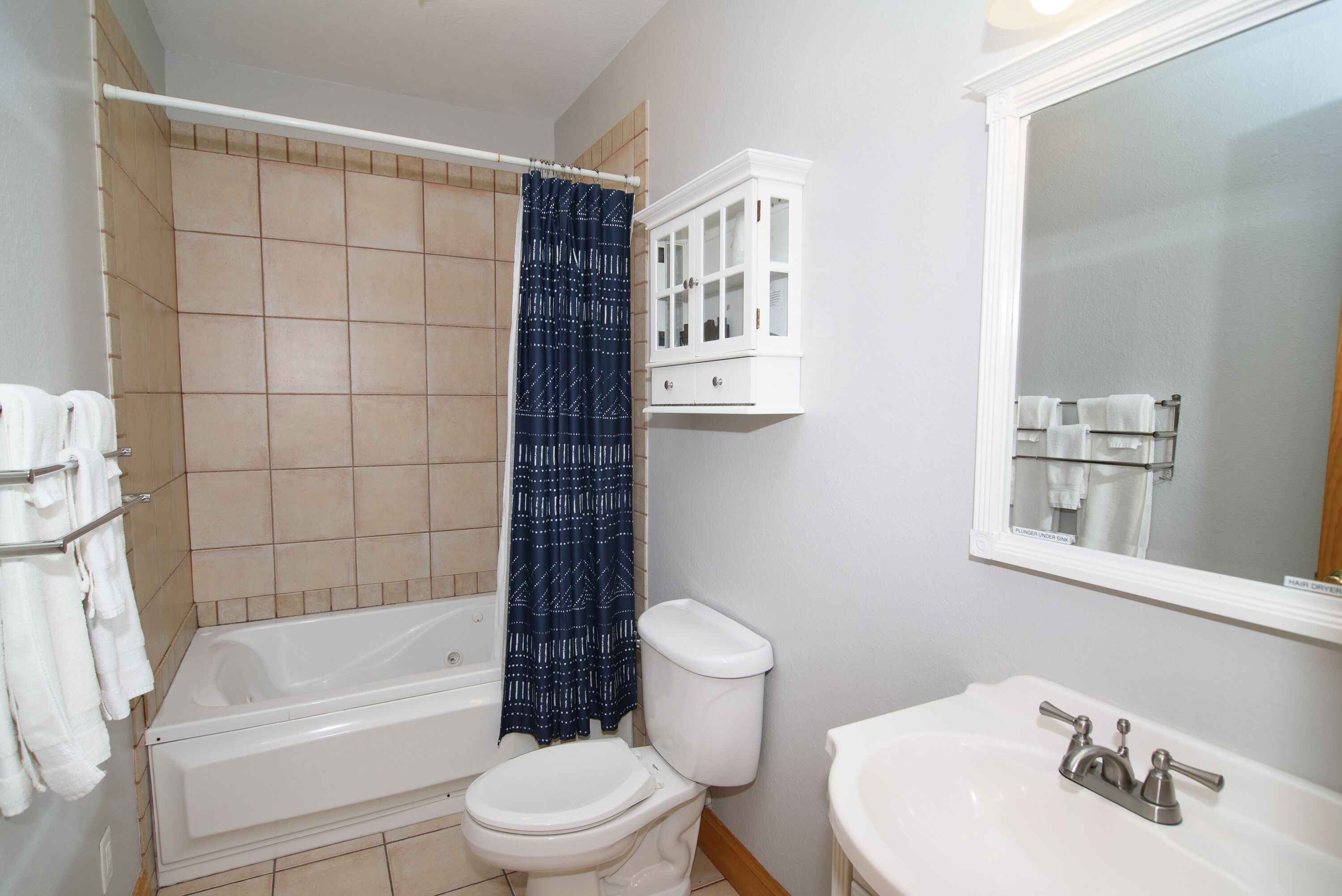 A bathroom with a bathtub, toilet, and sink.