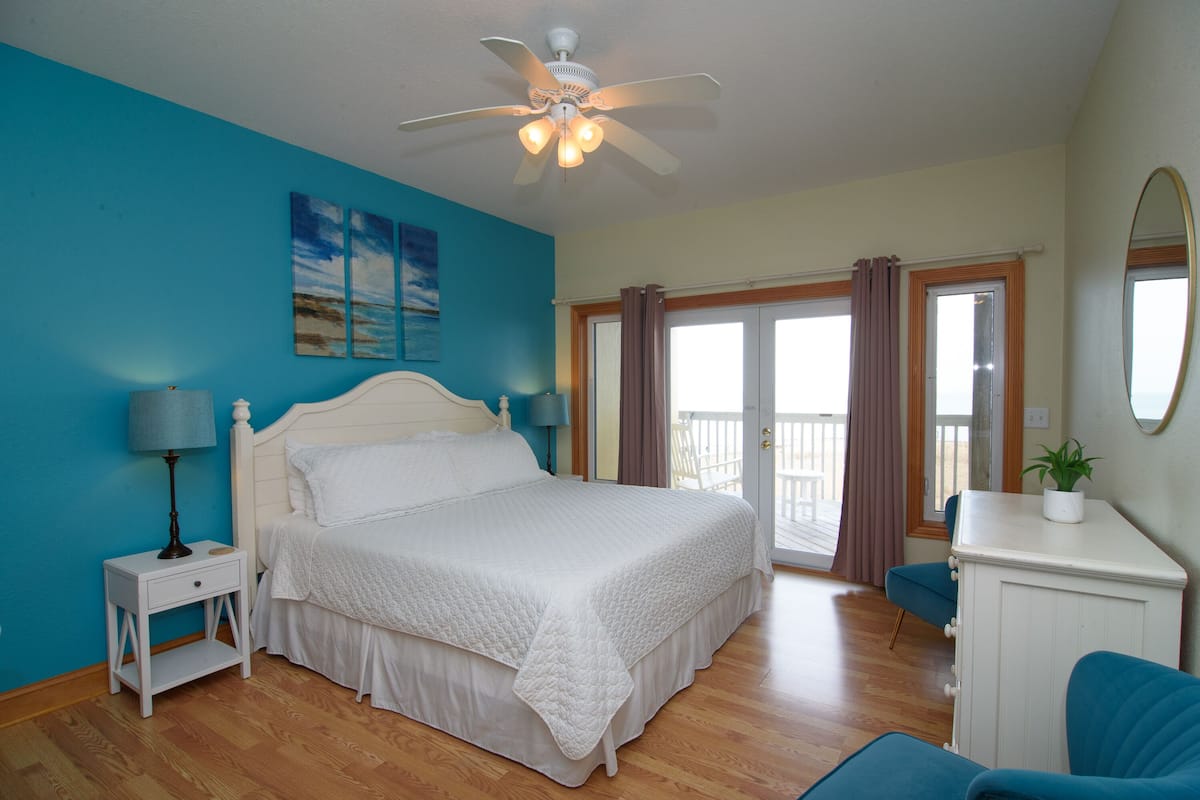 A bedroom with a bed, nightstand, dresser, and a ceiling fan.