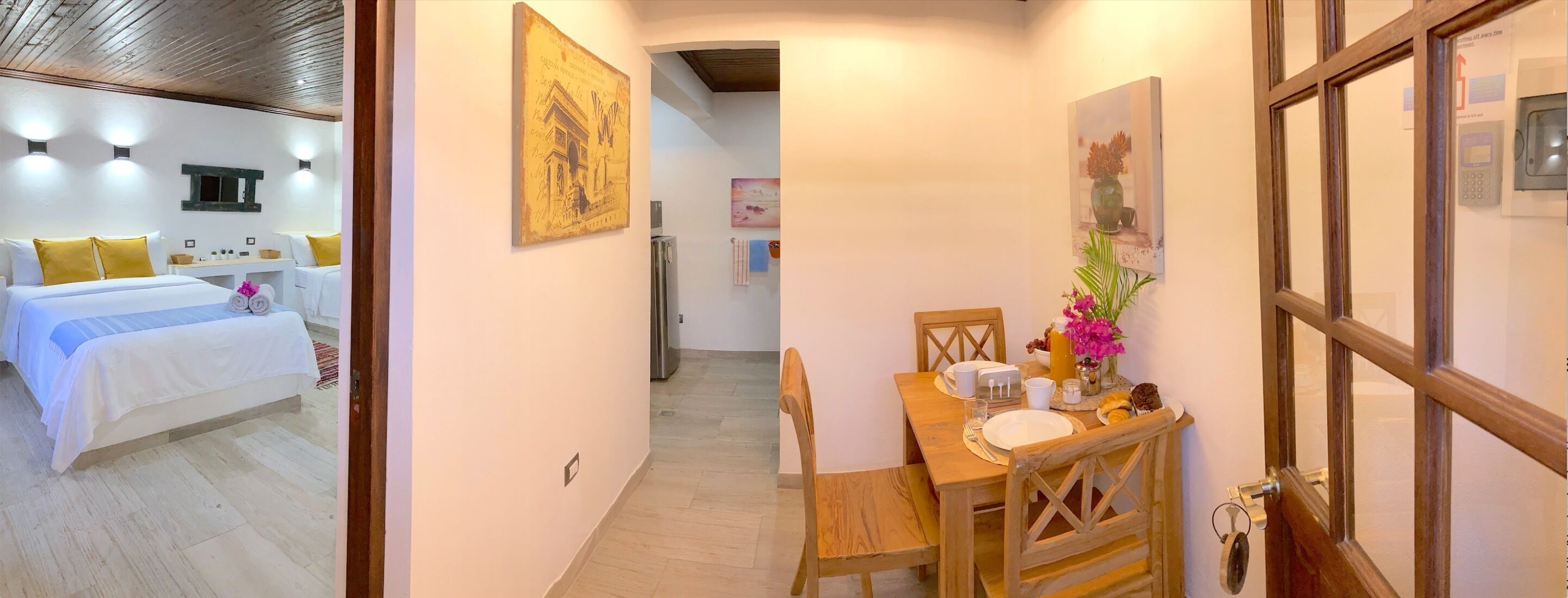 Una habitación de hotel con cama, mesita de noche y una pequeña zona de estar con mesa y sillones.