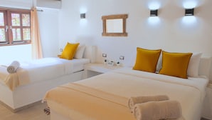 Una habitación de hotel con dos camas, una mesita y un espejo en la pared.