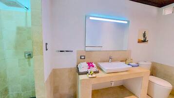 Ein Badezimmer mit Dusche, Waschbecken, Toilette und Spiegel.