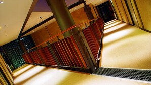A modern interior with a sloped ceiling, a metal staircase, and a patterned wall. - Droste's herberg (Tubbergen)