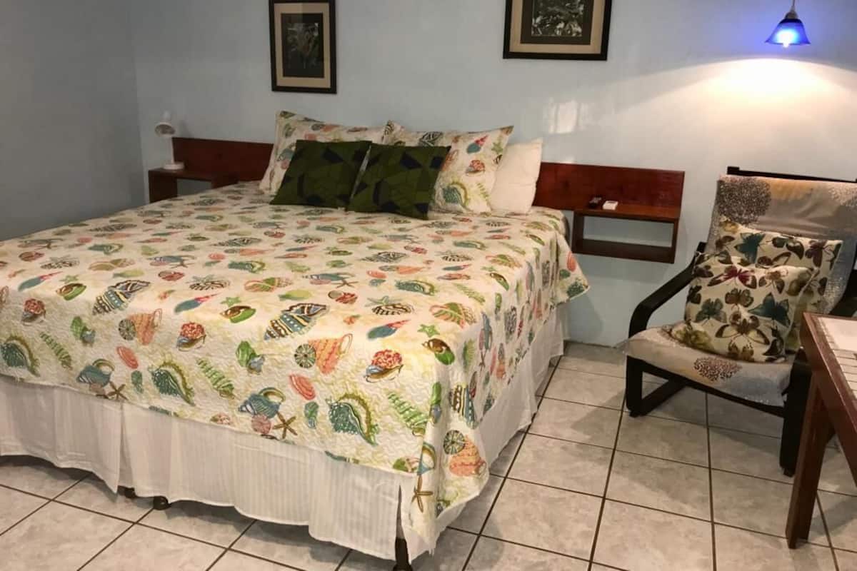 Ein Schlafzimmer mit einem Bett, einem Sessel und einem Nachttisch.