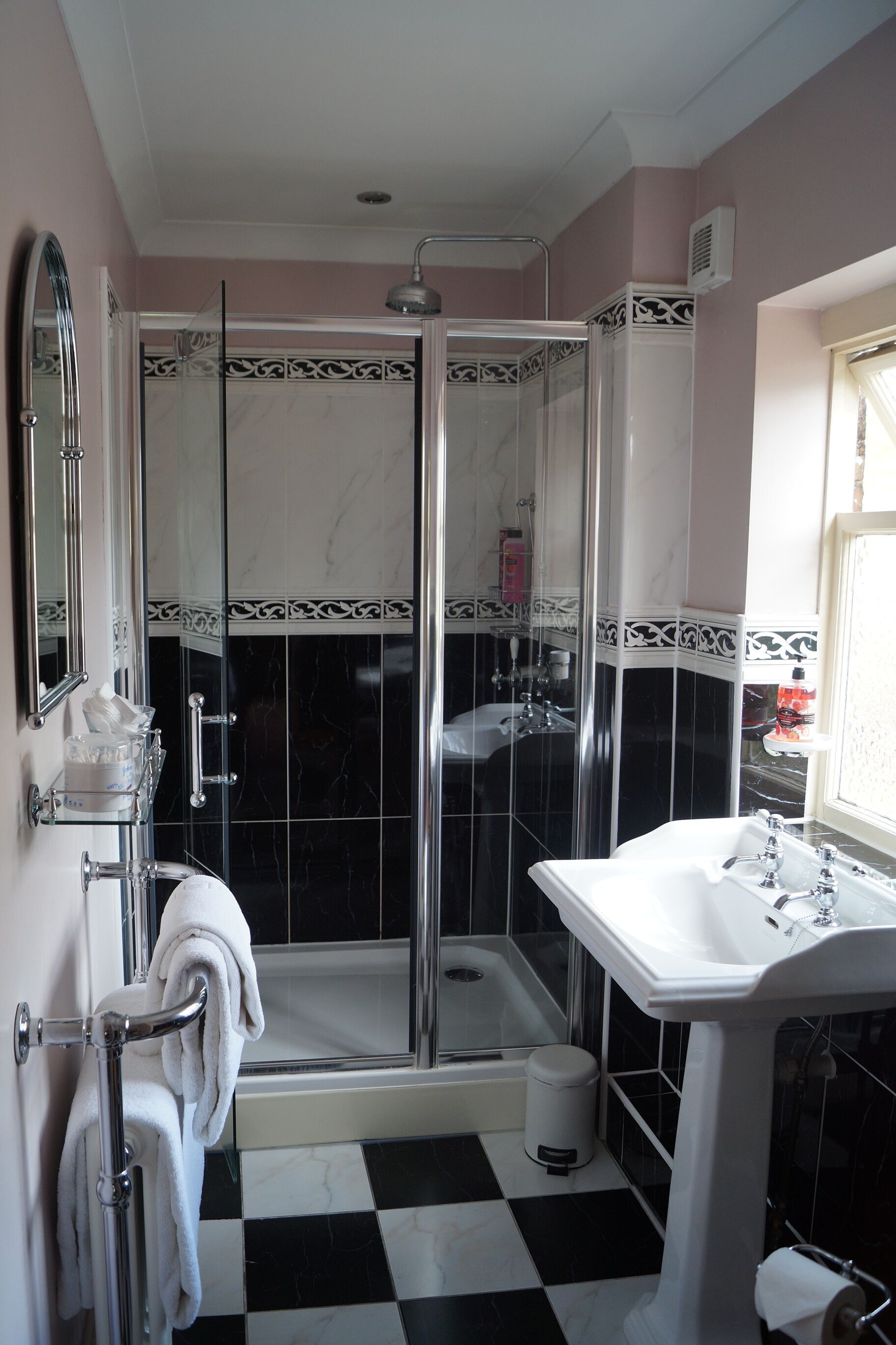 Une salle de bain avec une douche, un lavabo et un miroir.