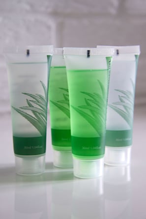 Quatre tubes transparents contenant un liquide vert, chacun étant étiqueté avec une image de plante et des informations sur le volume.