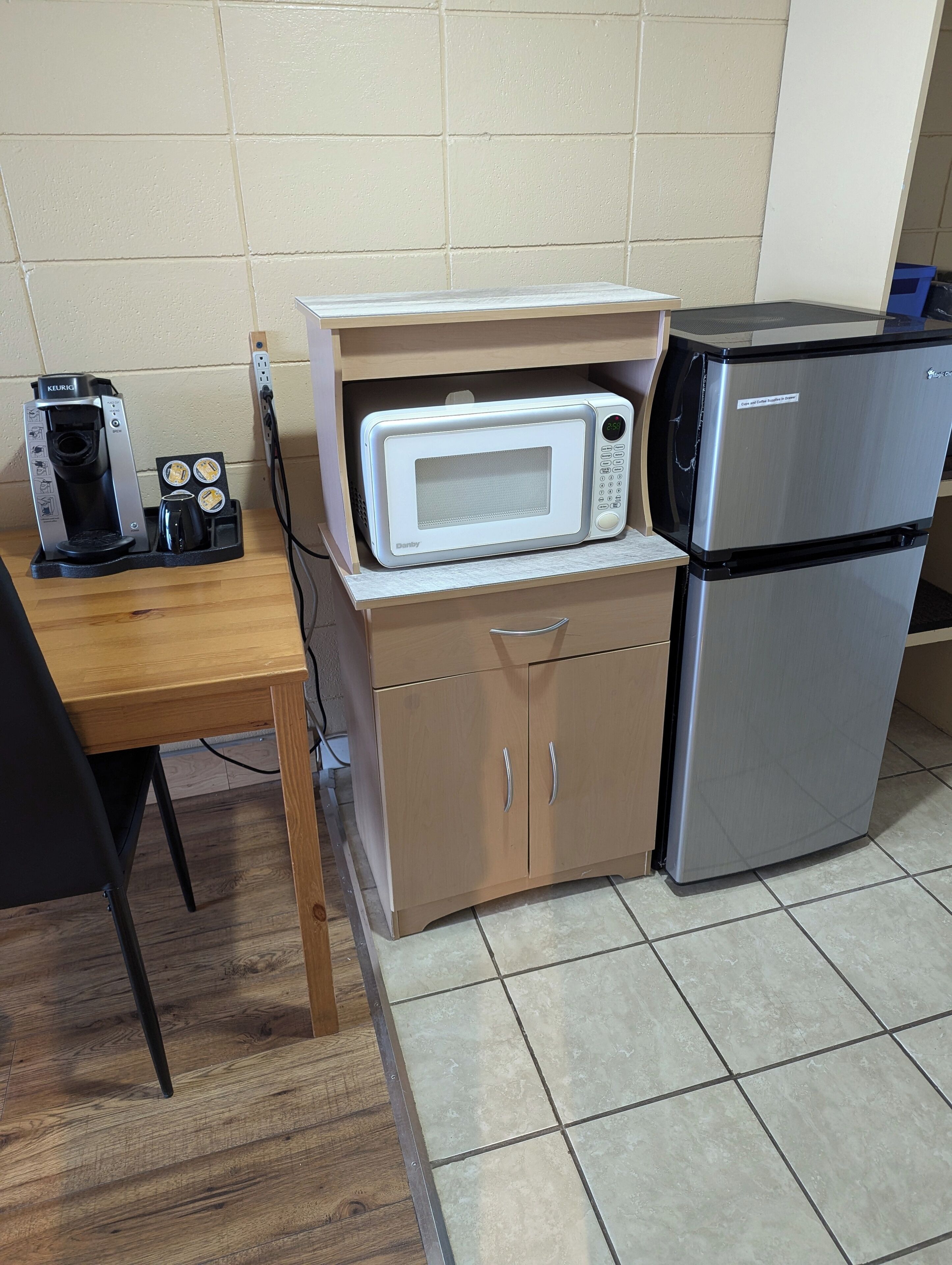 Una kitchenette compacta equipada con cafetera, microondas y refrigerador.