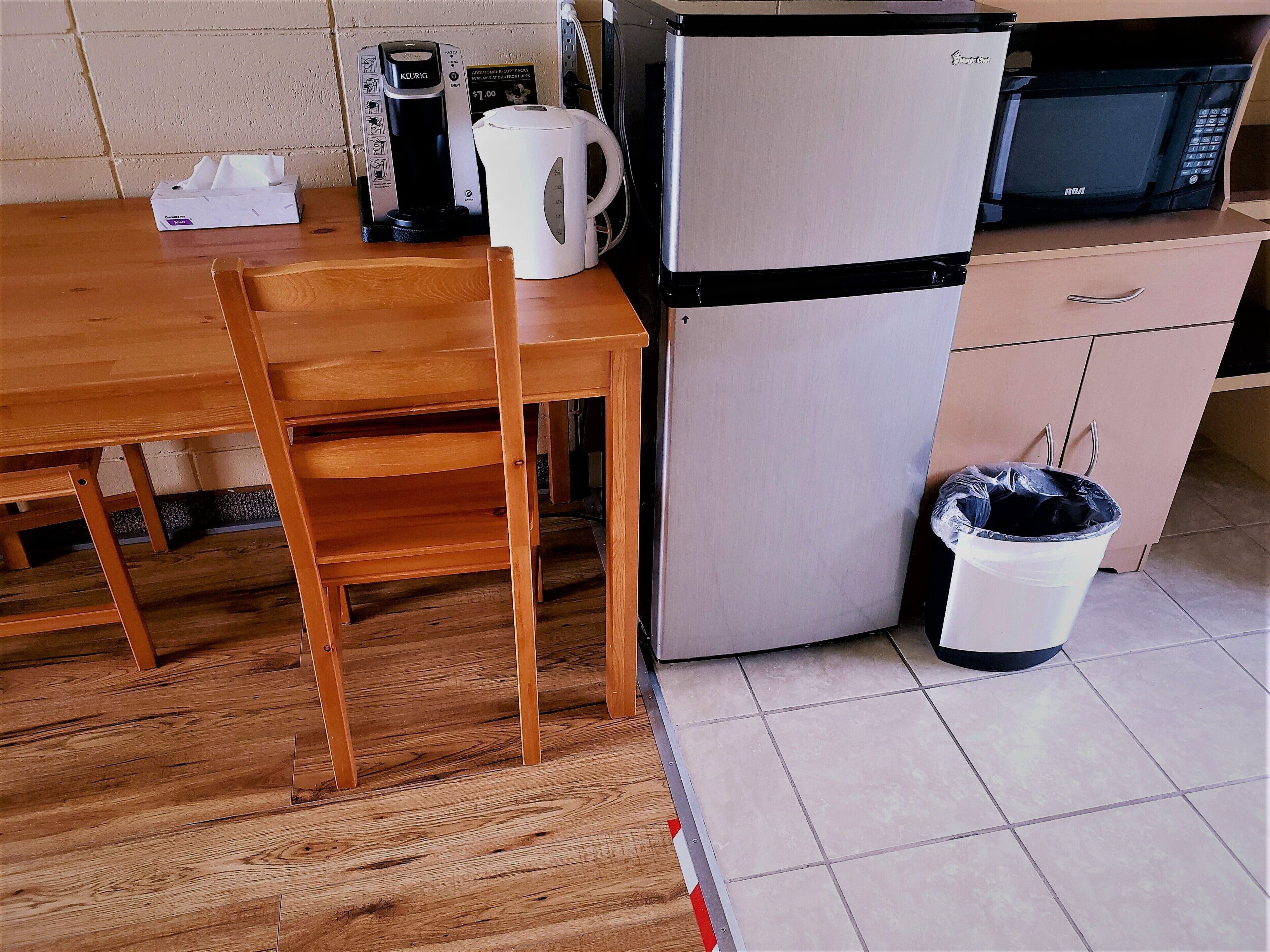 Una kitchenette equipada con cafetera, hervidor, microondas y refrigerador.