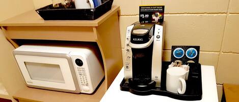 A kitchenette with a microwave, a Keurig coffee maker, and a coffee pod holder.