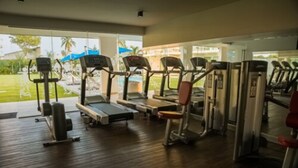 Ein Fitnessstudio mit Laufbändern, Crosstrainern und Krafttrainingsgeräten.