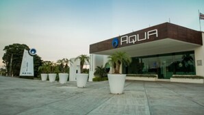 Ein moderner Hotelzugang mit einem Schild, auf dem "AQUA HOTEL" steht, und einer Flagge.