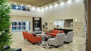 A spacious lobby with a high ceiling, a reception desk, and seating areas. - Pomeroy Inn And Suites Vermilion (Vermilion)
