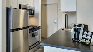 A modern kitchen with stainless steel appliances, a coffee maker, and a built-in microwave. - Pomeroy Inn And Suites Vermilion (Vermilion)