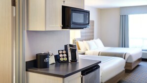 A compact hotel room with a kitchenette, a microwave, a coffee maker, and a bed with a view. - Pomeroy Inn And Suites Vermilion (Vermilion)