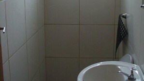 Un baño pequeño con inodoro, lavamanos y ventana.