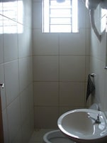 Un baño pequeño con inodoro, lavamanos y ventana.