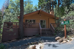 A small cabin with a wooden deck and a staircase leading to the entrance. - Yosemite Scenic Wonders - Wawona Area (Yosemite National Park)
