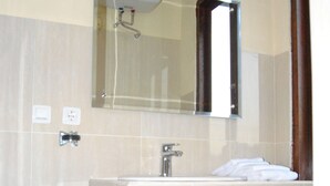 A bathroom with a sink, mirror, and towel rack. - Ganesha Home Stay (Ubud)