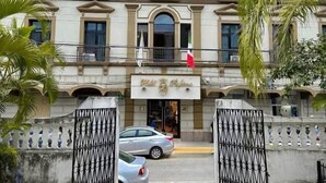 A building with a symmetrical facade, large windows, and a central entrance with a flag.