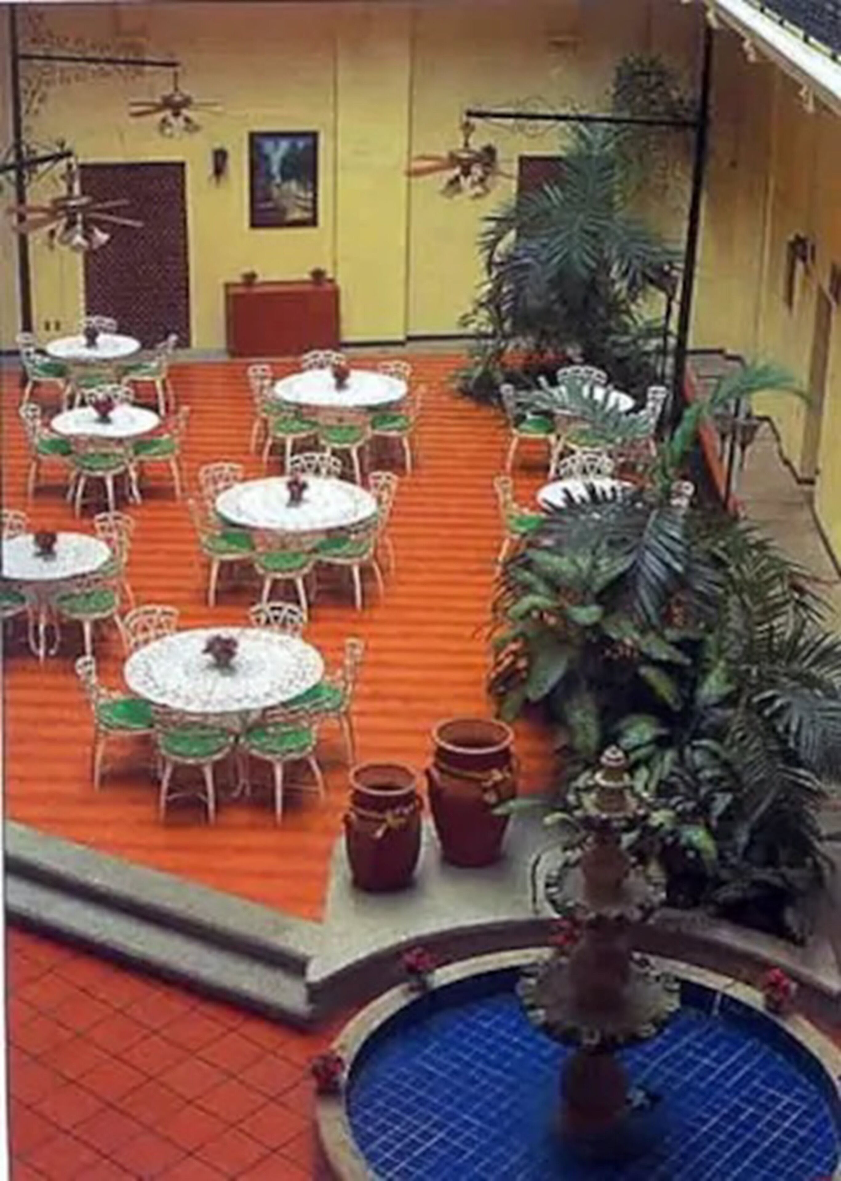 A courtyard with outdoor seating, a fountain, and potted plants.