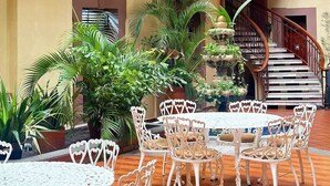 A courtyard with outdoor seating, a staircase, and a decorative fountain.