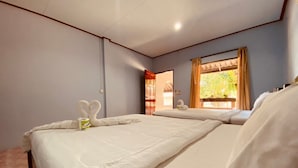 A hotel room with two beds, a window with curtains, and a door leading to another room. - Phupha Bungalow (Ko Pha-ngan)
