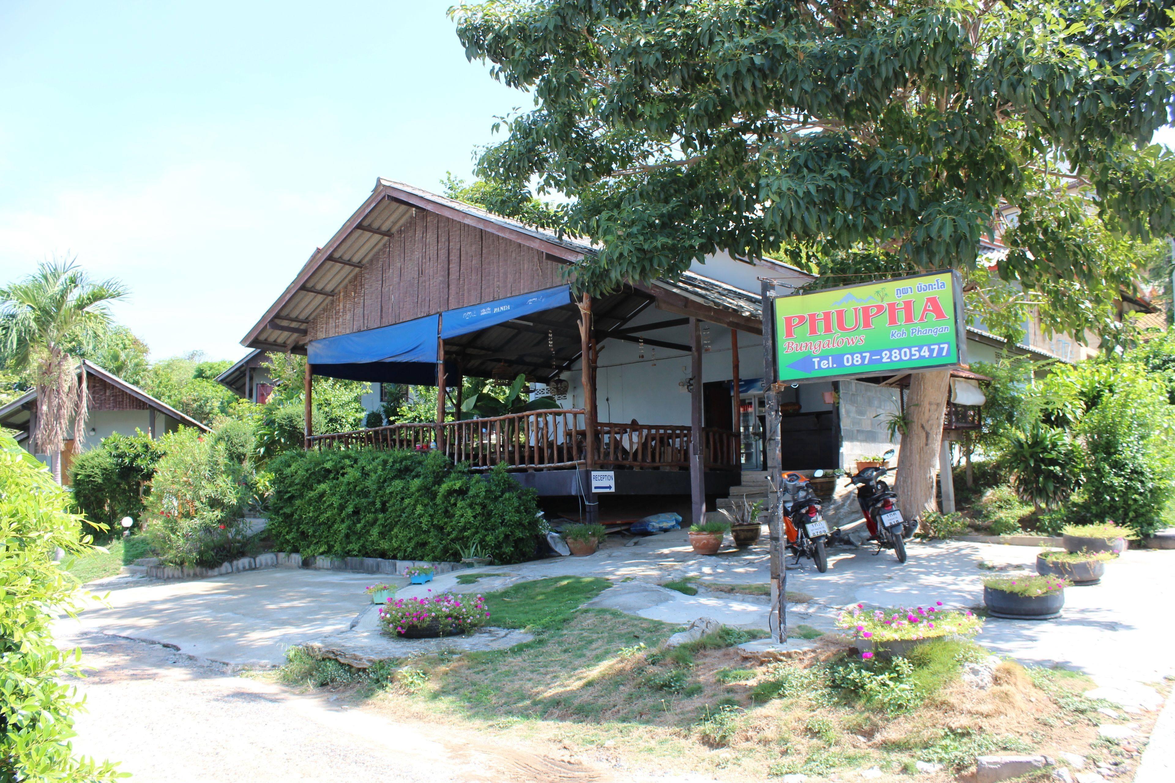 A building with a covered porch and a signboard.