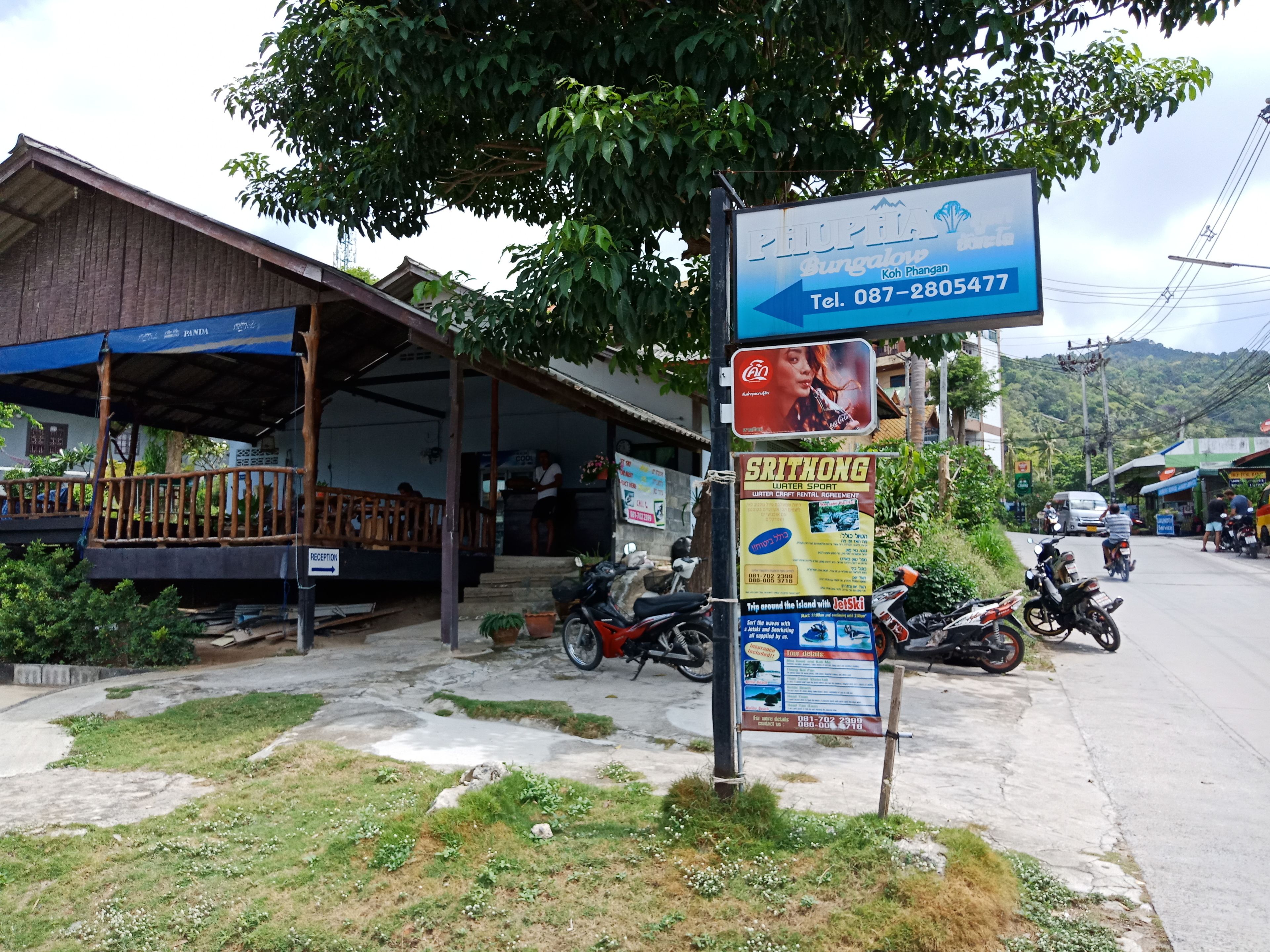 A building with a signboard advertising a bungalow and a reception area.