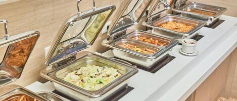 Buffet com diversas opções de comida em recipientes de metal.