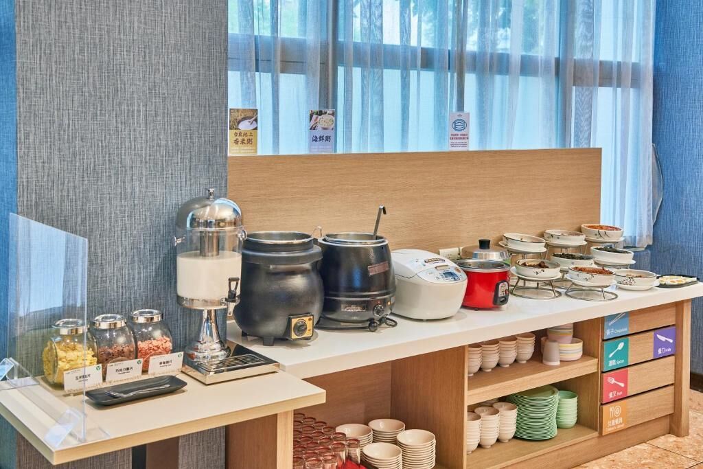A buffet setup with various food containers, a coffee machine, and a tea station.