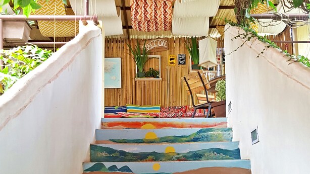 A staircase with painted murals depicting ocean scenes and surfers. - Gabby's Bed and Breakfast (Dumaguete)
