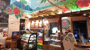 A restaurant with a tropical mural, a glass display case, and a sign for Gabby's BBQ. - Gabby's Bed and Breakfast (Dumaguete)
