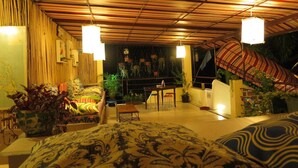 A room with a wooden ceiling, hanging plants, and a bed with patterned bedding. - Gabby's Bed and Breakfast (Dumaguete)