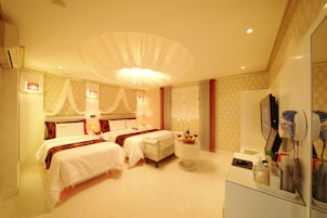 Habitación de hotel con dos camas, un tocador con espejo y una mesita con artículos de aseo.