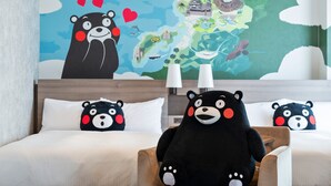 A hotel room with a large wall mural, a bed with white bedding, and two plush bear pillows.