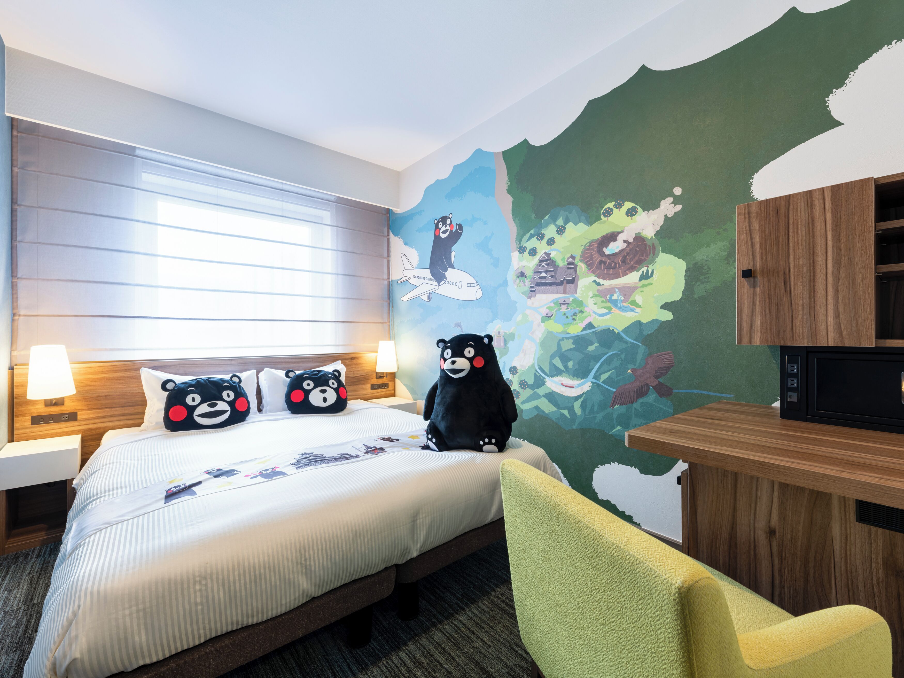 Une chambre d’hôtel avec un lit, une chaise, un bureau et une fresque murale.