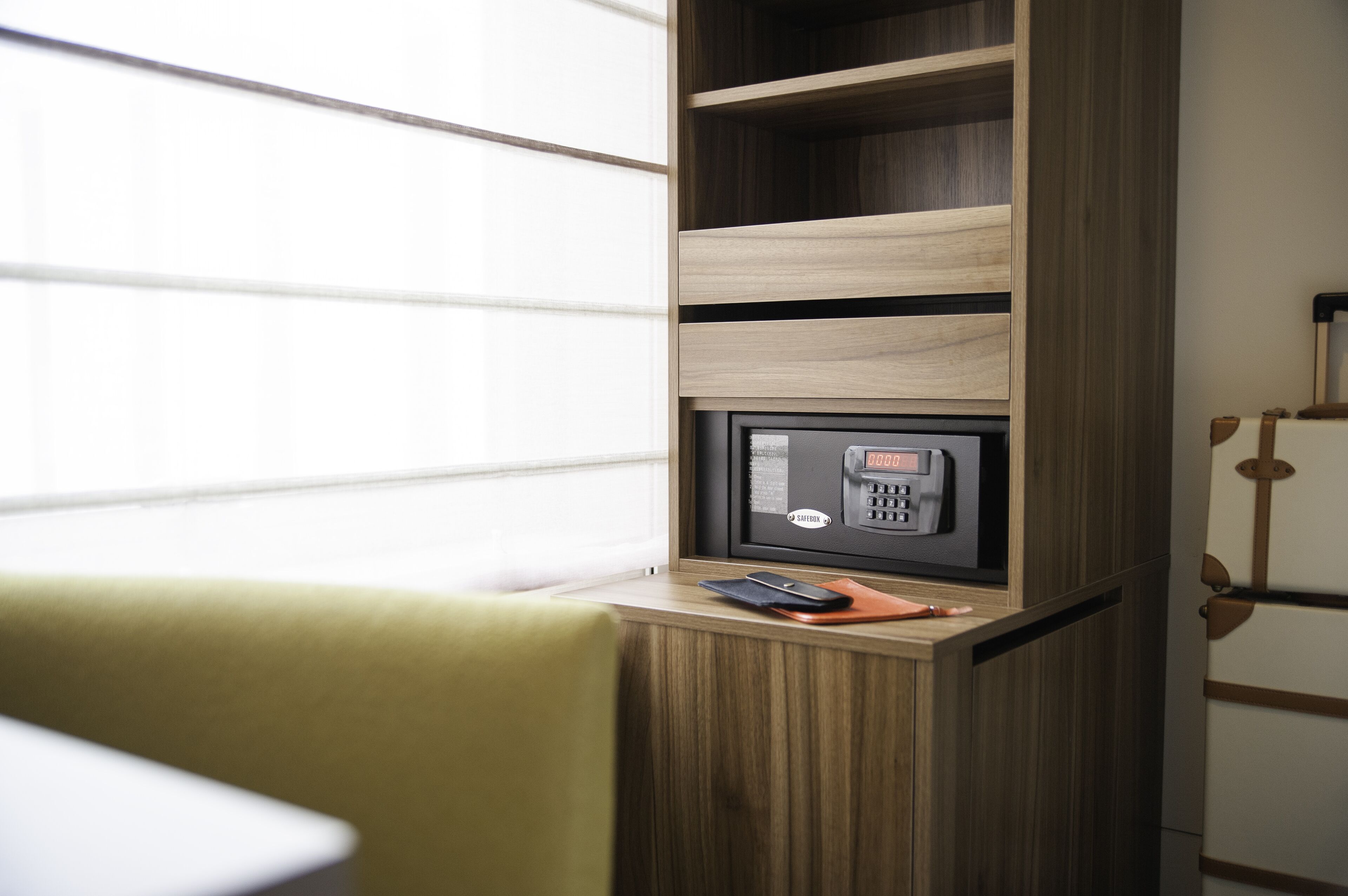 Ein Holzschrank mit integriertem Mikrowellenherd und ein kleiner Tisch mit Telefon und Notizbuch.