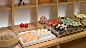 A buffet setup with various food items and a decorative basket.