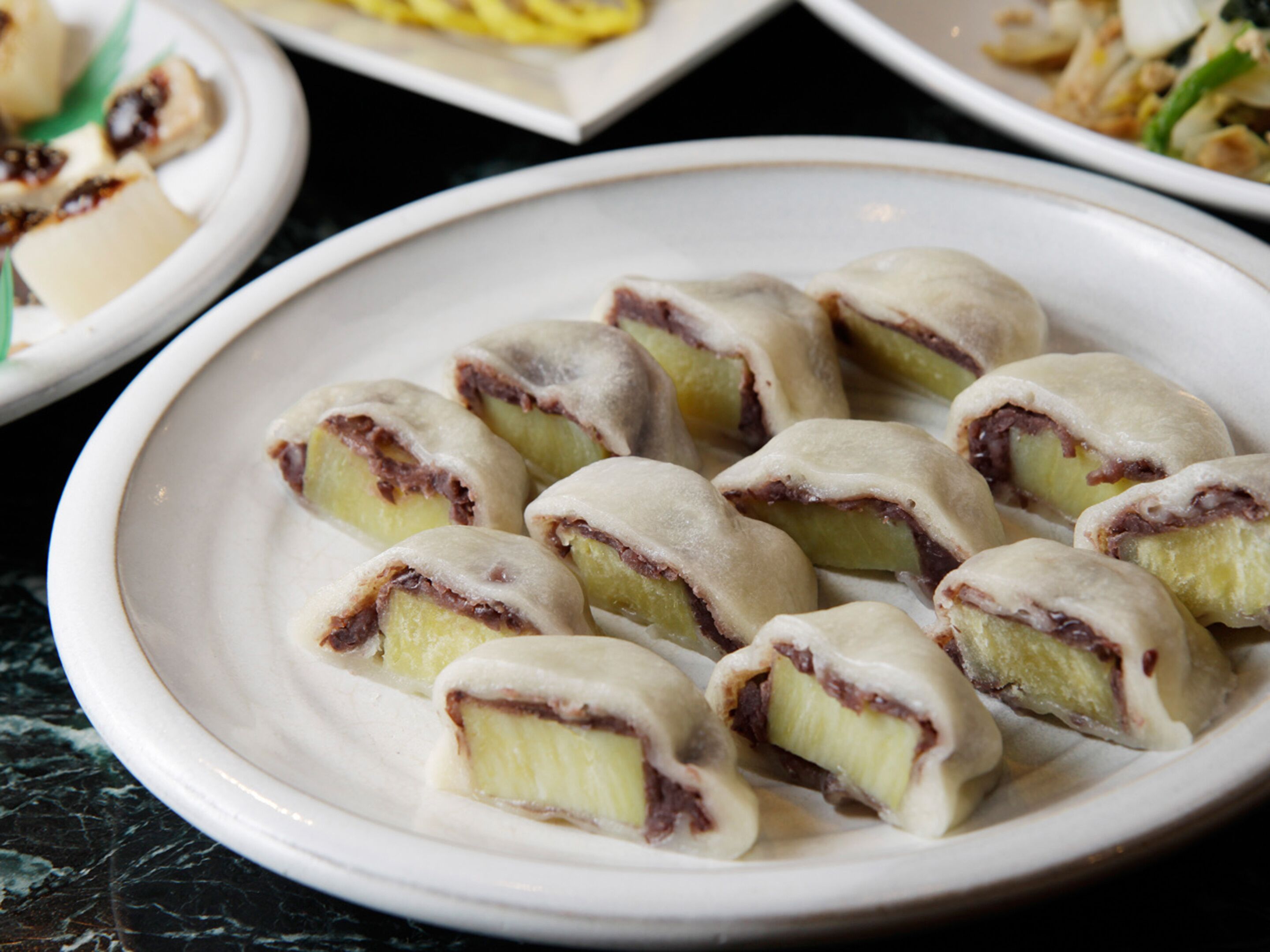 A plate of pastries with a creamy filling and a chocolate layer, served on a white plate.